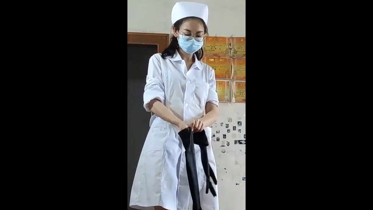 细心的女护士戴上长手术手套给病人护理