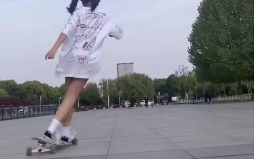 A cute, cuddly, big-headed, double-ponytailed longboarder.