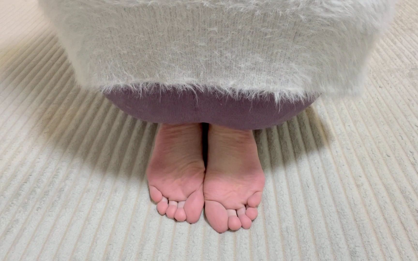 Barefoot, sitting upright and punching the back of the feet