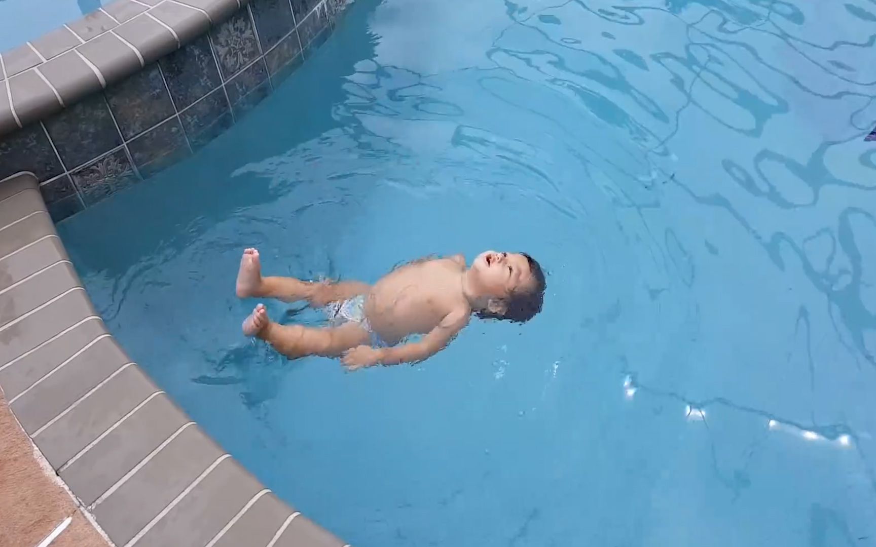 1岁胖娃飞速游过12米泳池，游泳动作太奇特，和鱼儿一样灵活