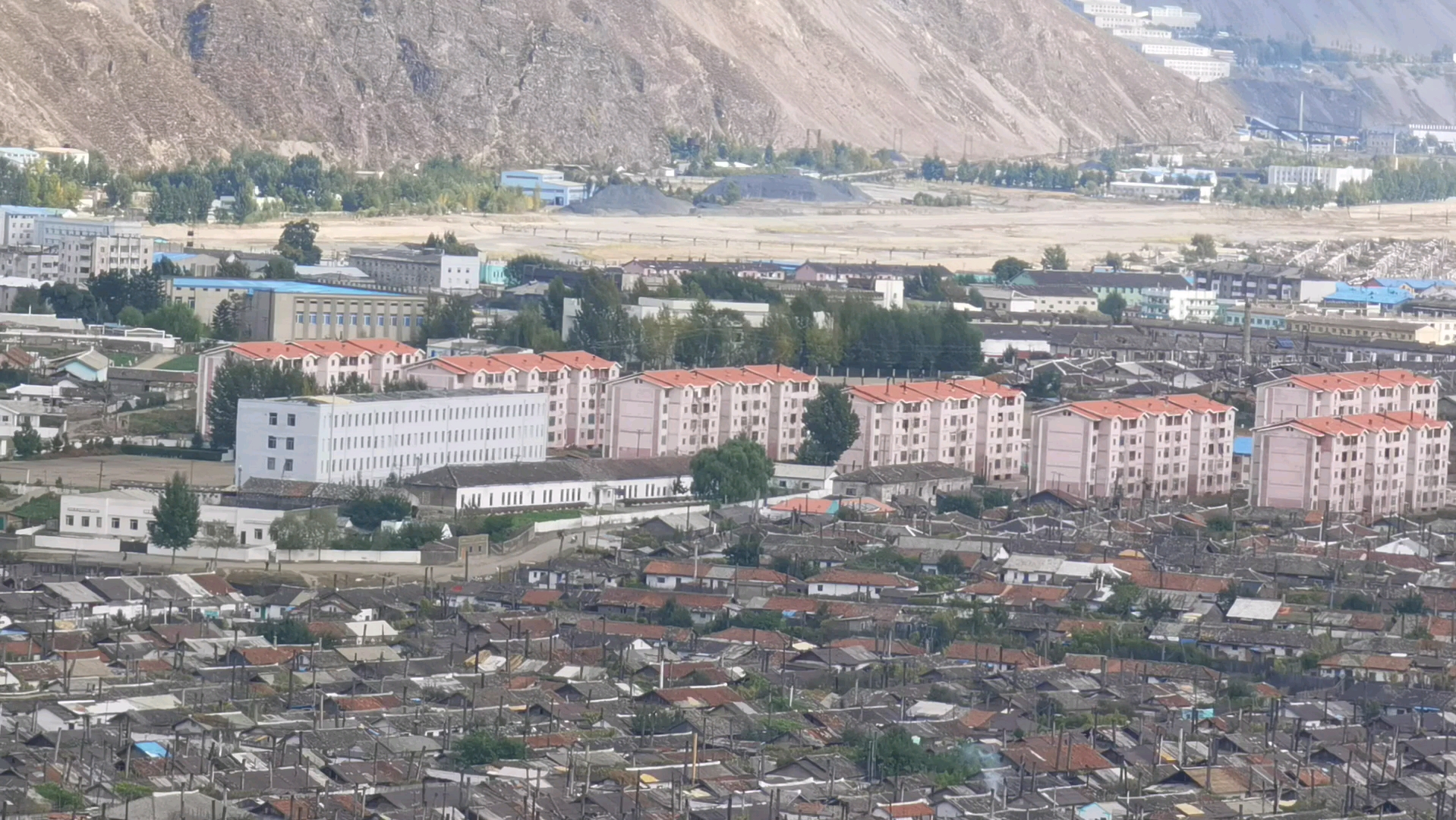 一江之隔看朝鲜茂山郡城市建设与居民生活的风貌。原本有机会发展很好，只可惜毁约和我们的铁矿合约，错失了机会