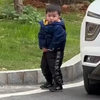 小男孩刚想脱下裤子方便，发现有人偷拍，尴尬又不失礼貌的微笑