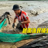 渔民在退潮的沟渠里布置渔网，这样抓鱼太爽了
