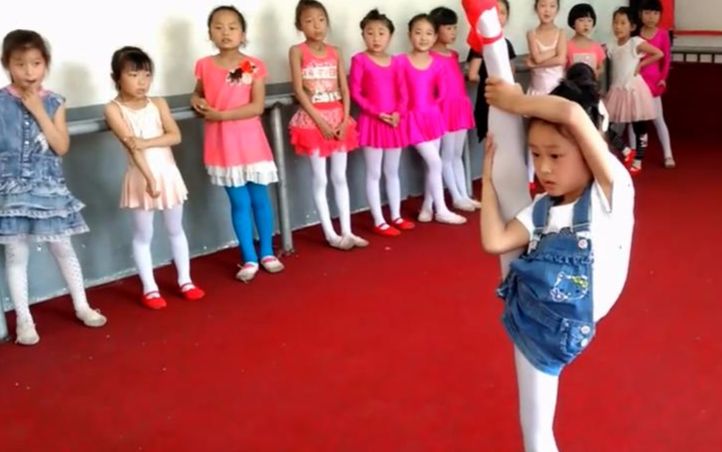 舞蹈班的小学女生们在练功房比赛单腿站立