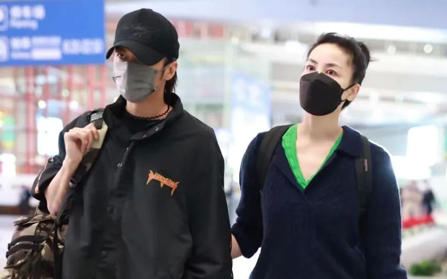王菲谢霆锋回北京了，菲姐勾男友手臂一脸爱意，画面超甜