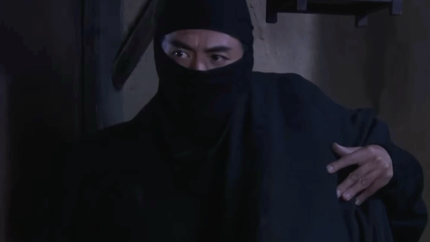 黑衣蒙面人扛着东西跑酷