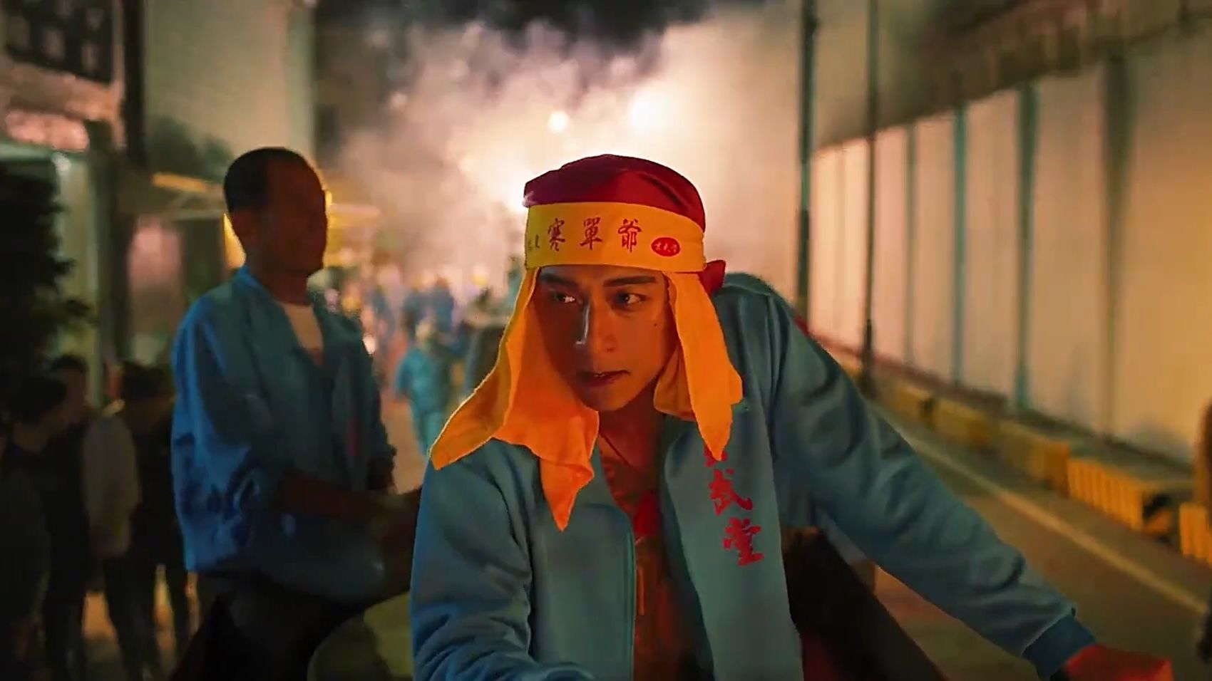 男人佩戴红黄相间头巾，半身赤裸，手持溶叶站在神轿之上《韩单》