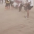 甘肃敦煌沙尘暴突袭旅游团:几十米高的黄沙像一堵移动沙墙滚滚而来 ，游客众人蹲在一起抱团避险