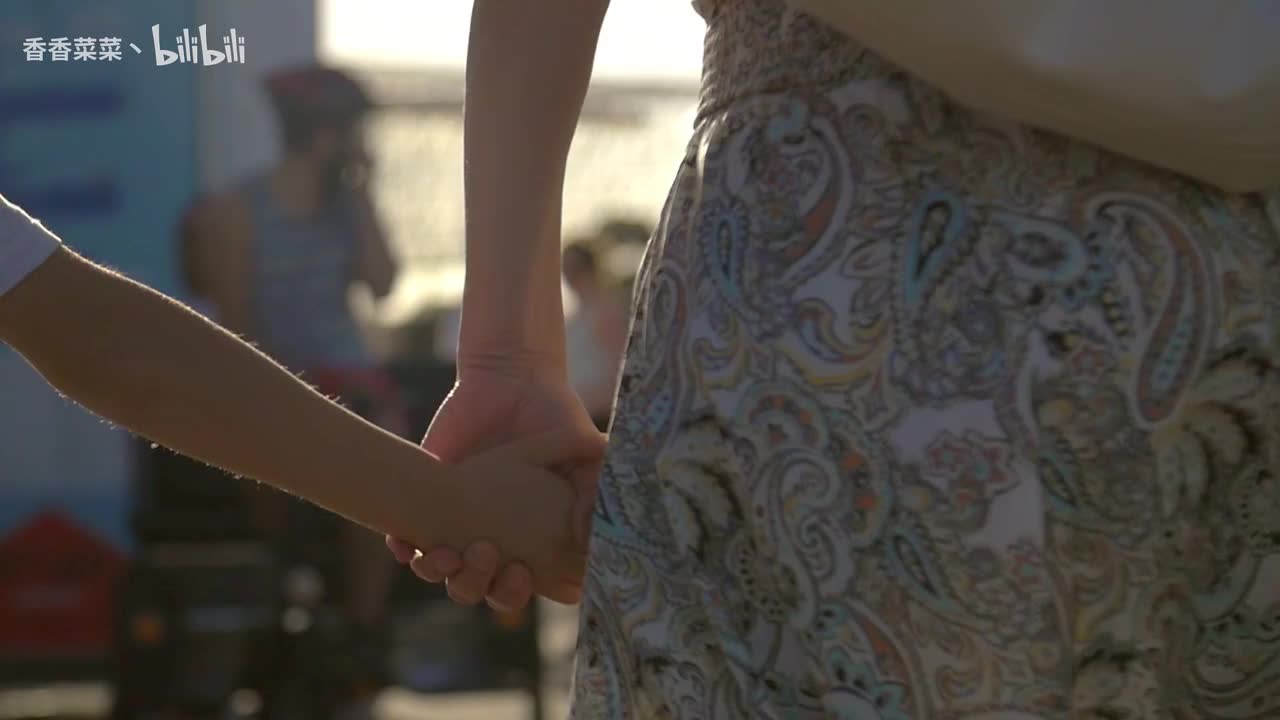 母亲牵着孩子的手走在大街上_