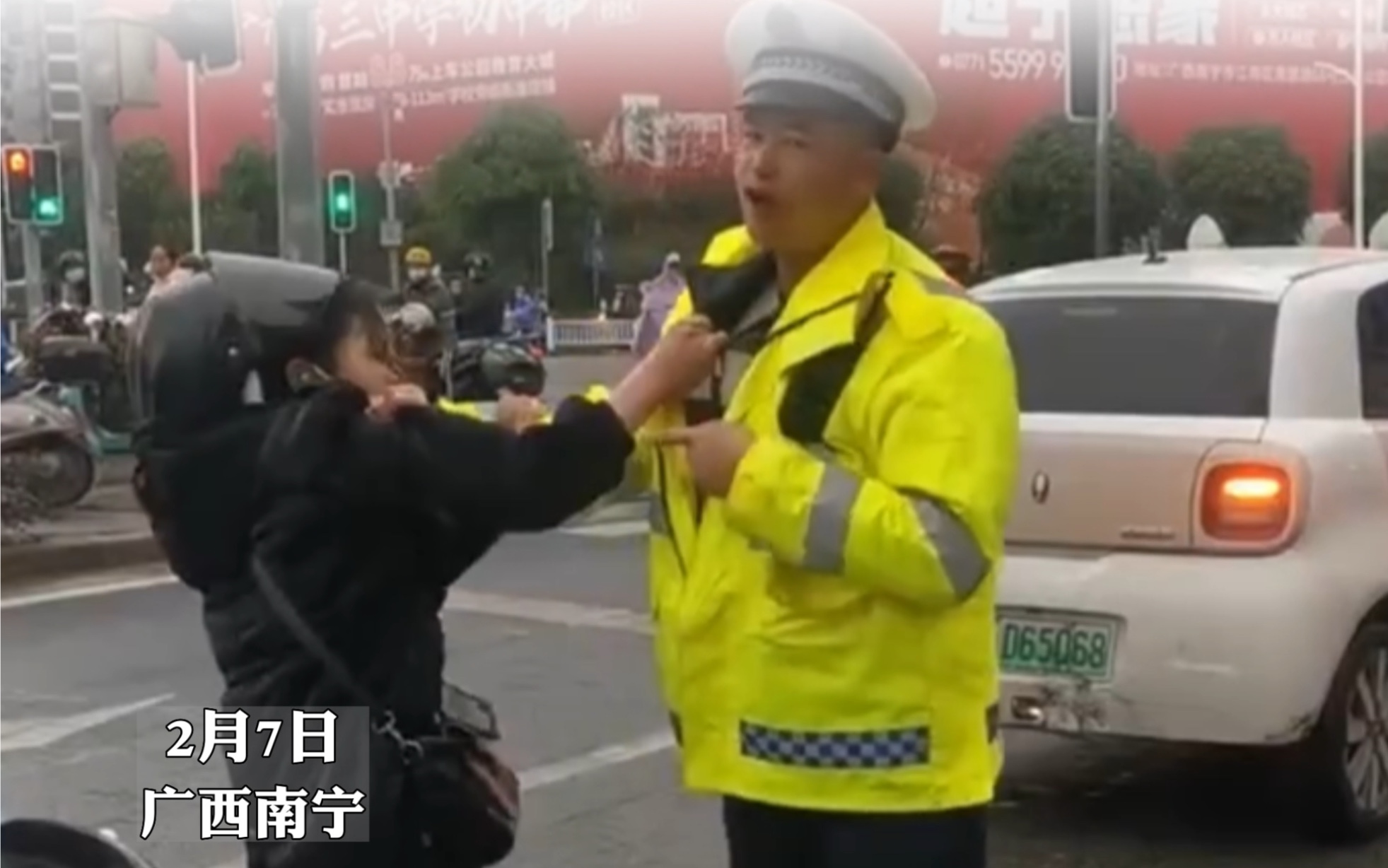 [图]2月7日，广西南宁。女子骑电动车追尾私家车，在事故处置时撕扯交警撒泼，抓住交警衣服不放，胡搅蛮缠，交警劝说无果后果断将女子放倒。围观者：早就该放倒她。