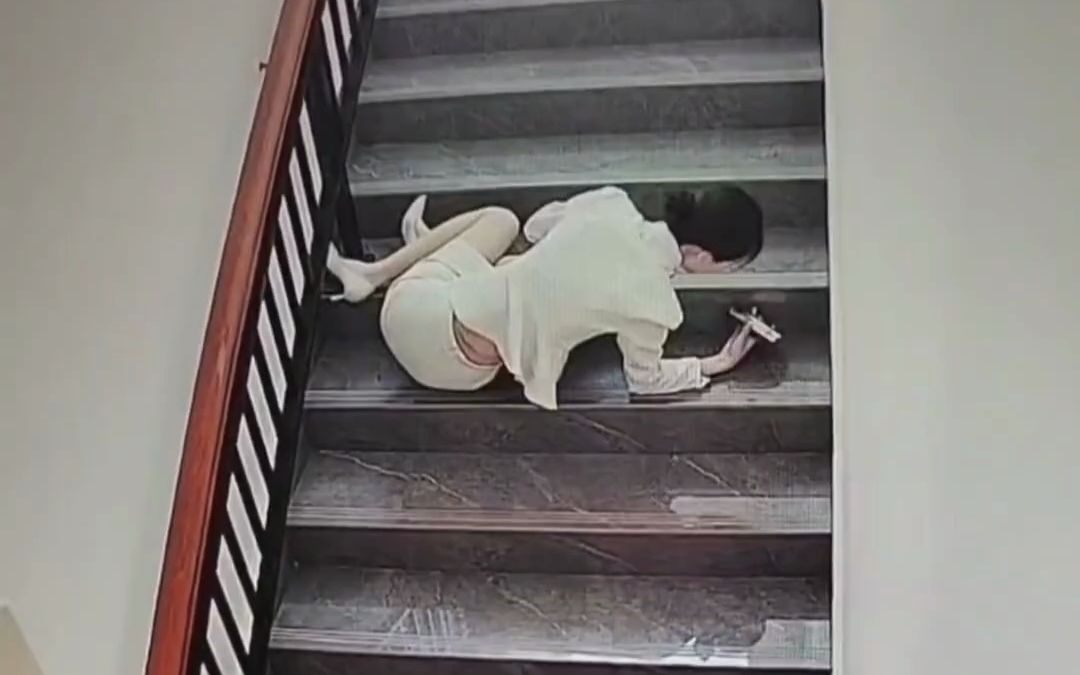 穿高跟鞋的美女从楼梯上摔倒滑下,摔倒后第一时间检查手机是否损坏.
