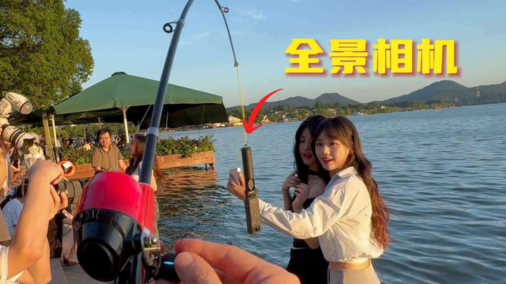 拿钓鱼杆给小姐姐拍照