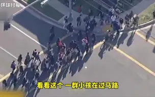 Descargar video: 美国警匪驾车枪战，路遇学生放学过马路双方暂停