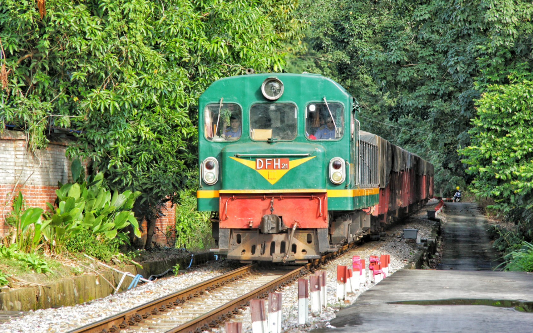 【中国铁道】昆河铁路-越南铁路东方红21(d10h-006)牵引货列行驶在村