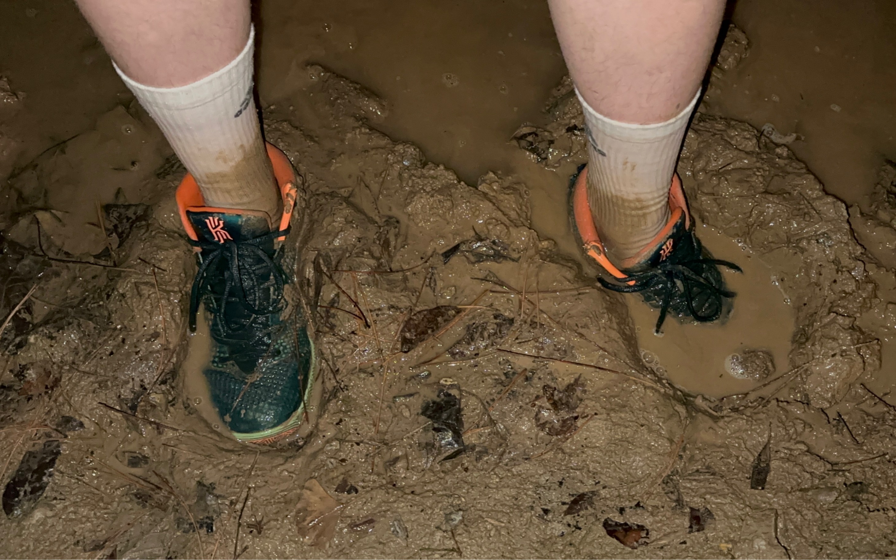 篮球鞋和白袜踩在在泥滩中