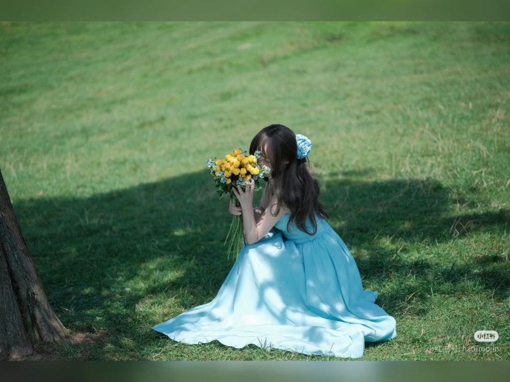 94蓝裙少女草地捧花束,梦幻笑容温暖人心