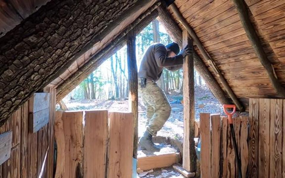 男子独自一人来到森林里砍树搭建小木屋搭建温暖的庇护所