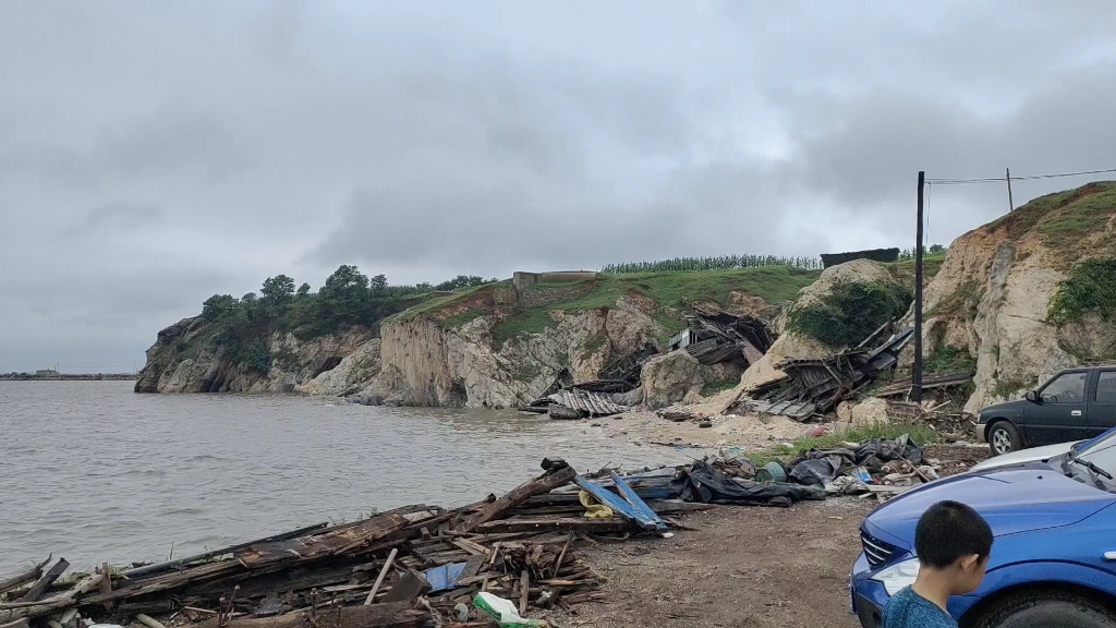 皮口凉水湾海边的修船基地,海边堆积很多的废弃换下来的船木,海水把船