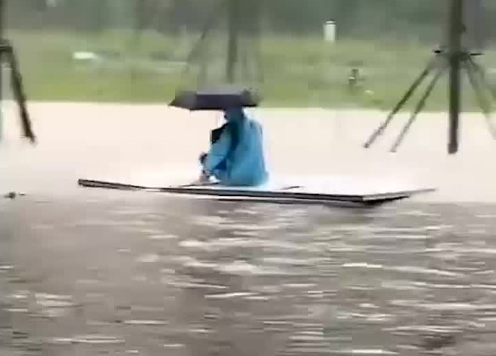 河南暴雨道路积水成河,一市民被困木板上一路漂流,网友:好无助哔哩哔哩bilibili