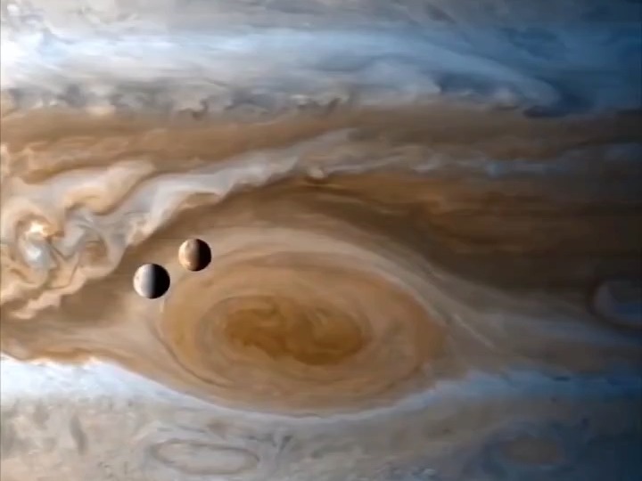 美国卡西尼探测器2001年飞掠木星时,木卫一和木卫二飞过大红斑(卡西尼