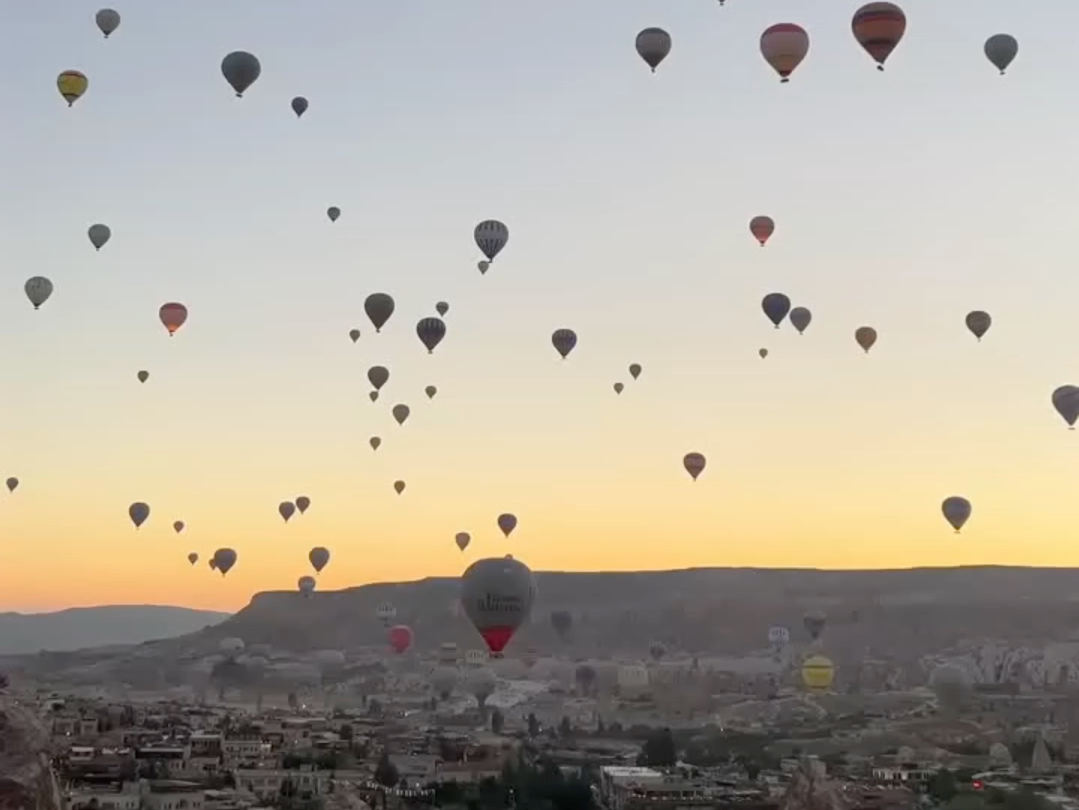 卡帕多西亚的独特地貌与天际间漂浮的五彩缤纷的热气球相结合,呈现出