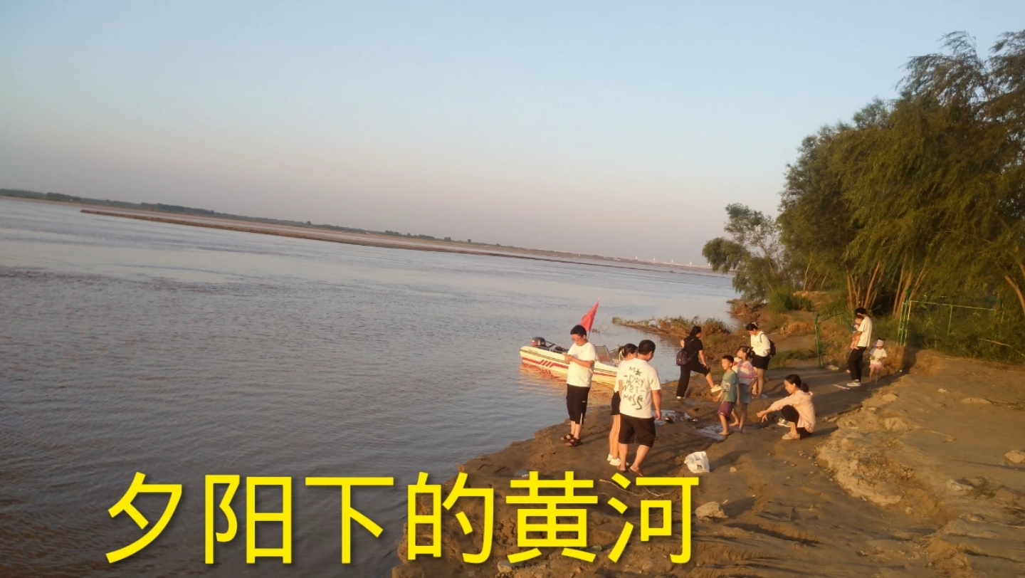夏日黄昏,来郑州黄河边看落日,遇到有人在踏浪