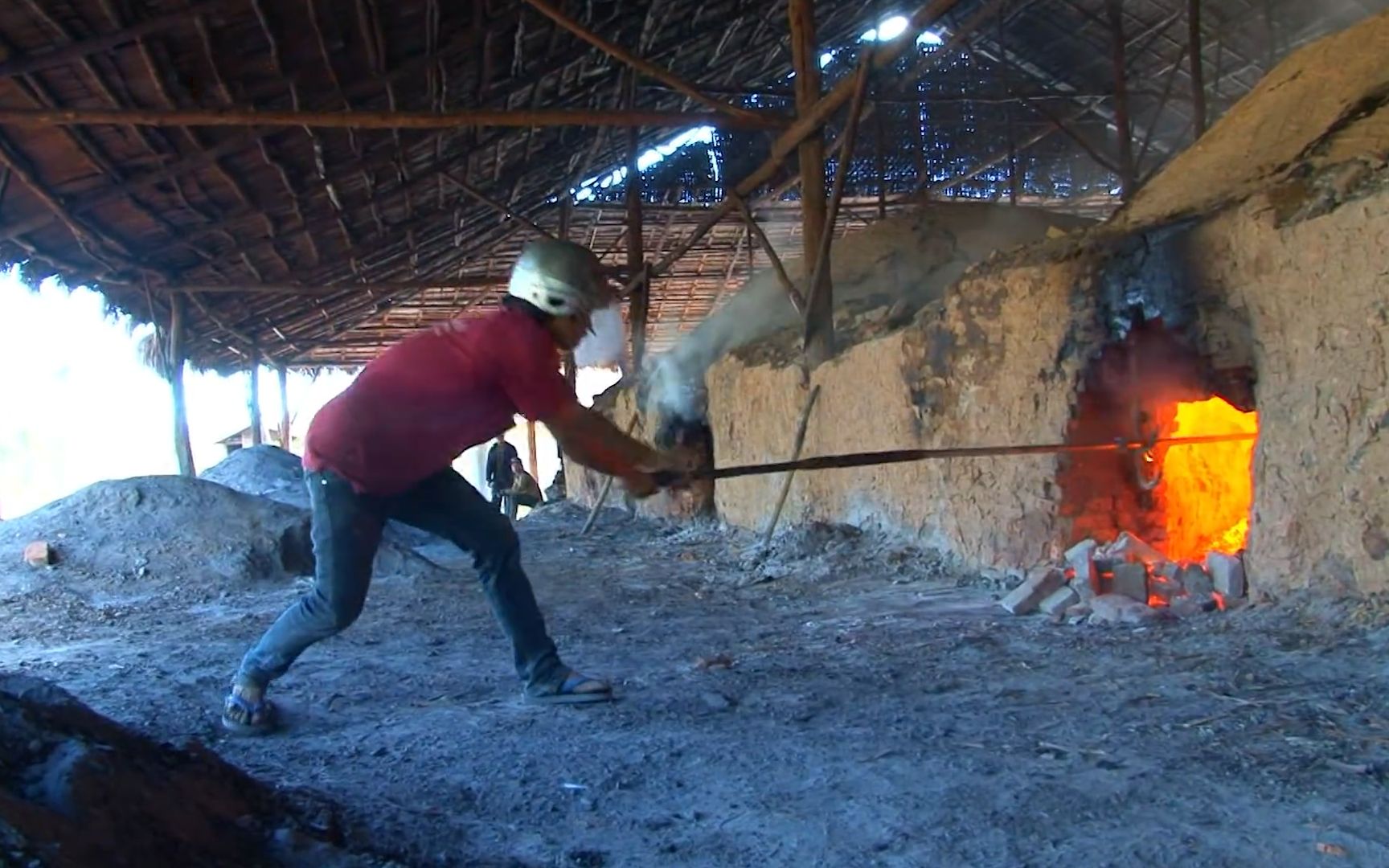 老挝木炭厂的黑窑工,举着铁棍在1000℃下工作,七八个人睡在一块