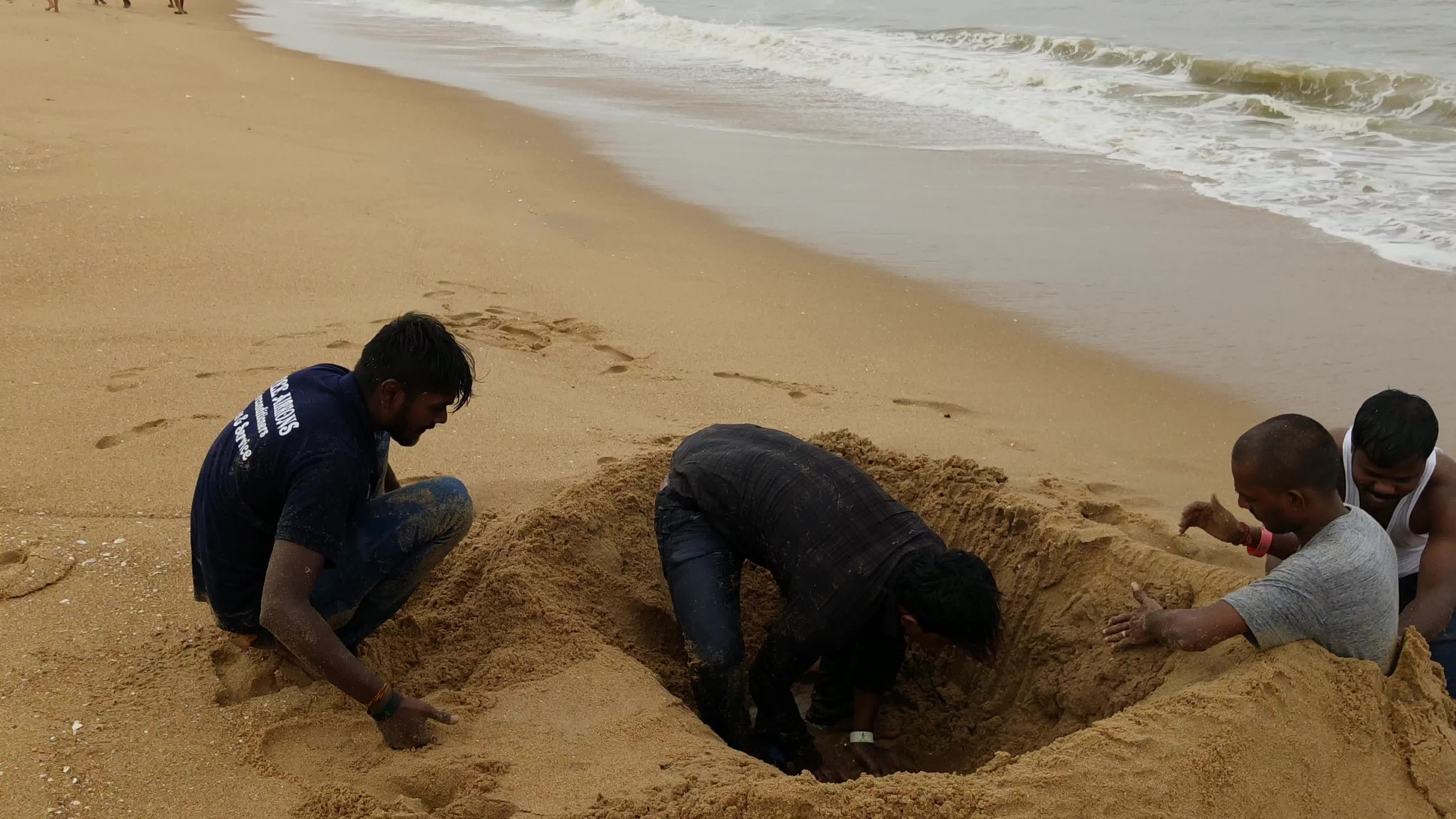 印度人海边挖坑埋自己