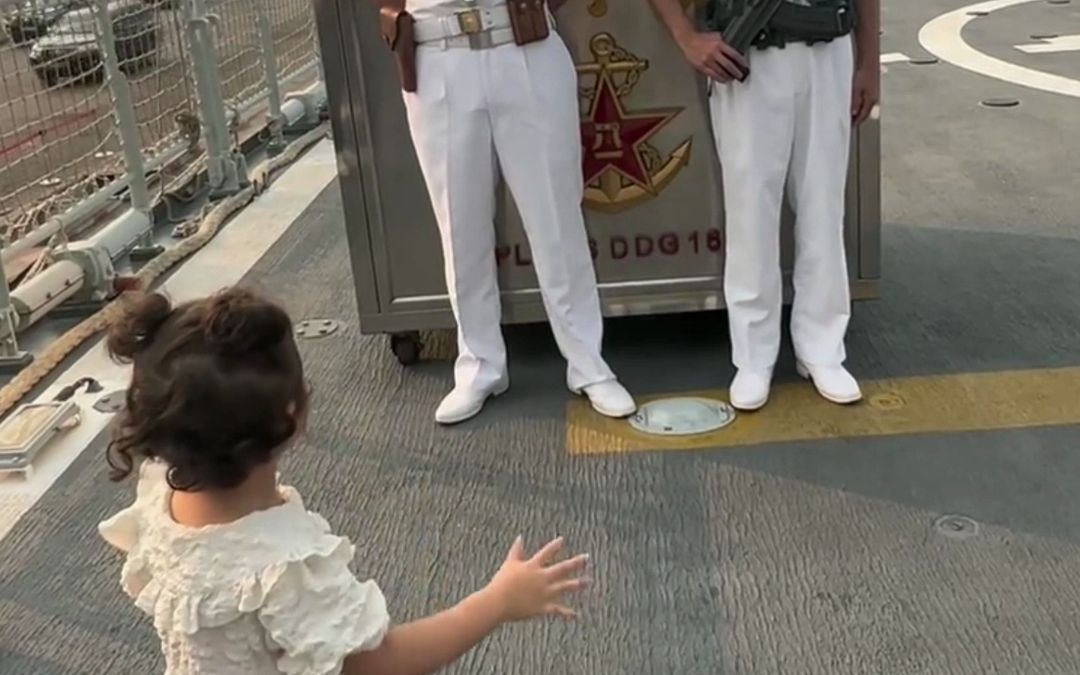 中国3岁女孩在刚果(布)登上南宁舰参观,与海军官兵互相敬礼.