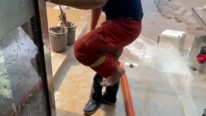 帅哥抗洪消防战士脱雨靴光脚倒水