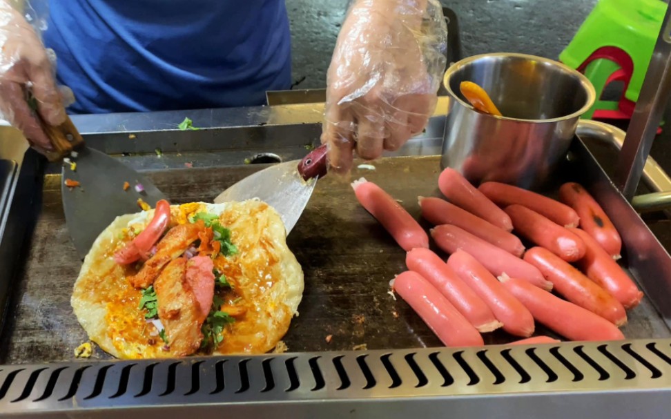 路边摊手抓饼,加肠加鸡柳9块钱一个,看老板操作很干净卫生