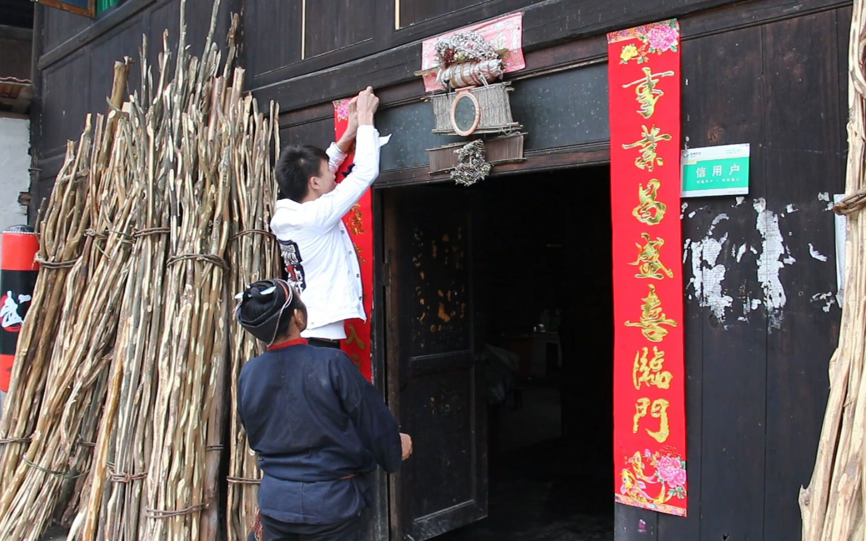 過年啦農村小夥和母親在門口貼對聯祝大家新年快樂