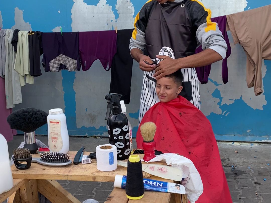 小男孩在加沙避难所的沙龙里理发