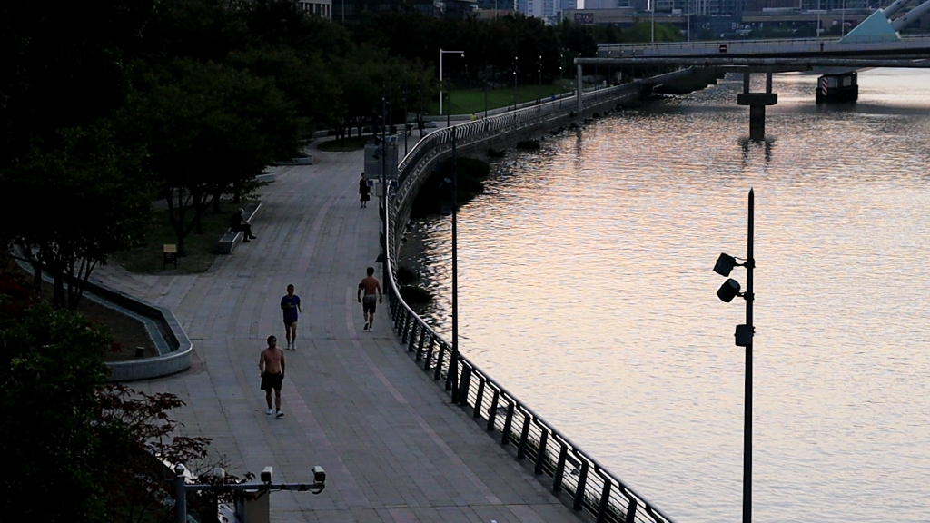 清晨江边的散步跑步者