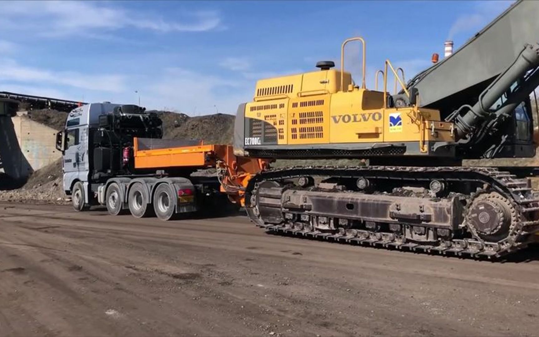 实拍平板拖车转运工程机械到工地