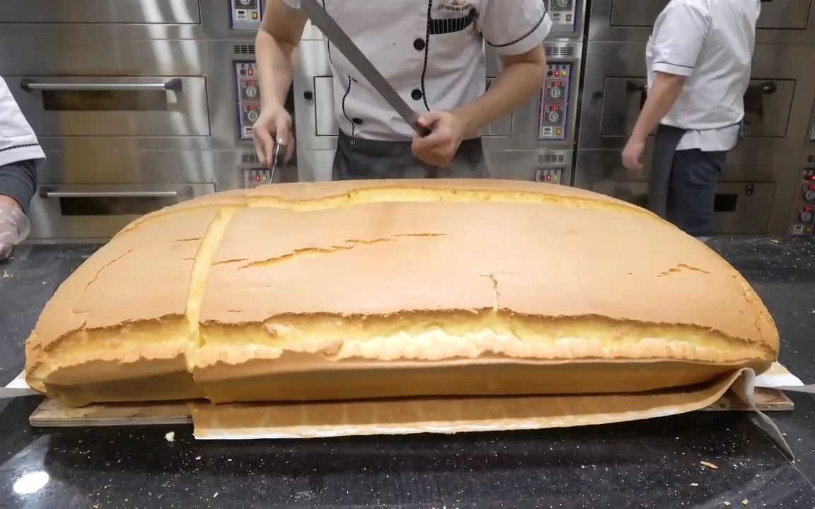 超大的原始味蛋糕摇摇欲坠的蛋糕切割