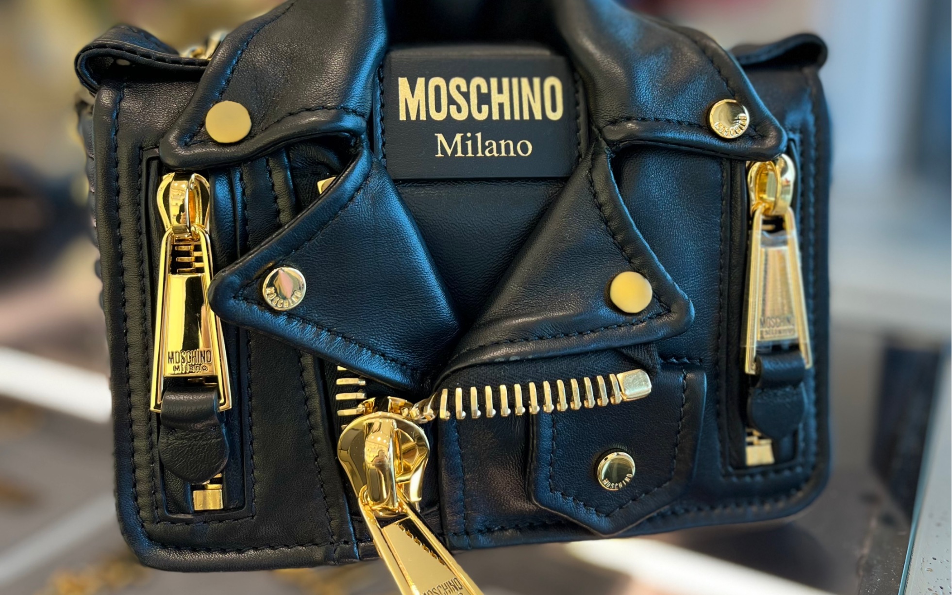 moschino经典延续机车包黑金款 产地意大利,由150块小羊皮打磨而成