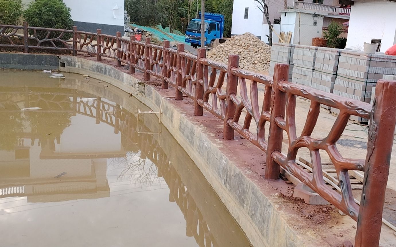 村里鱼池塘安装栏杆,有了水泥仿树藤护栏再也不用担心落水了