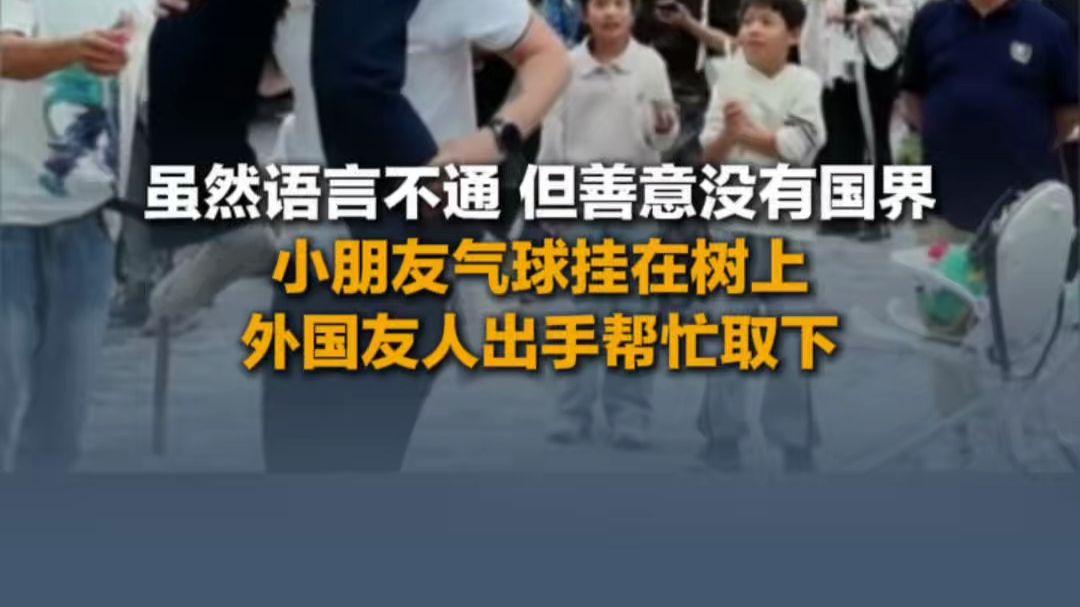 10月5日（报道），虽然语言不通，但善意没有国界，小朋友气球挂在树上外国友人出手帮忙取下