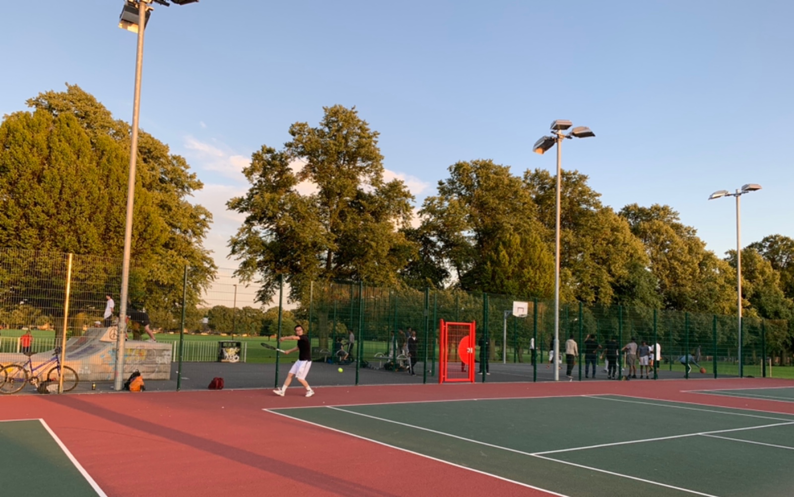 英国乡村业余网球爱好者傍晚在公园对拉